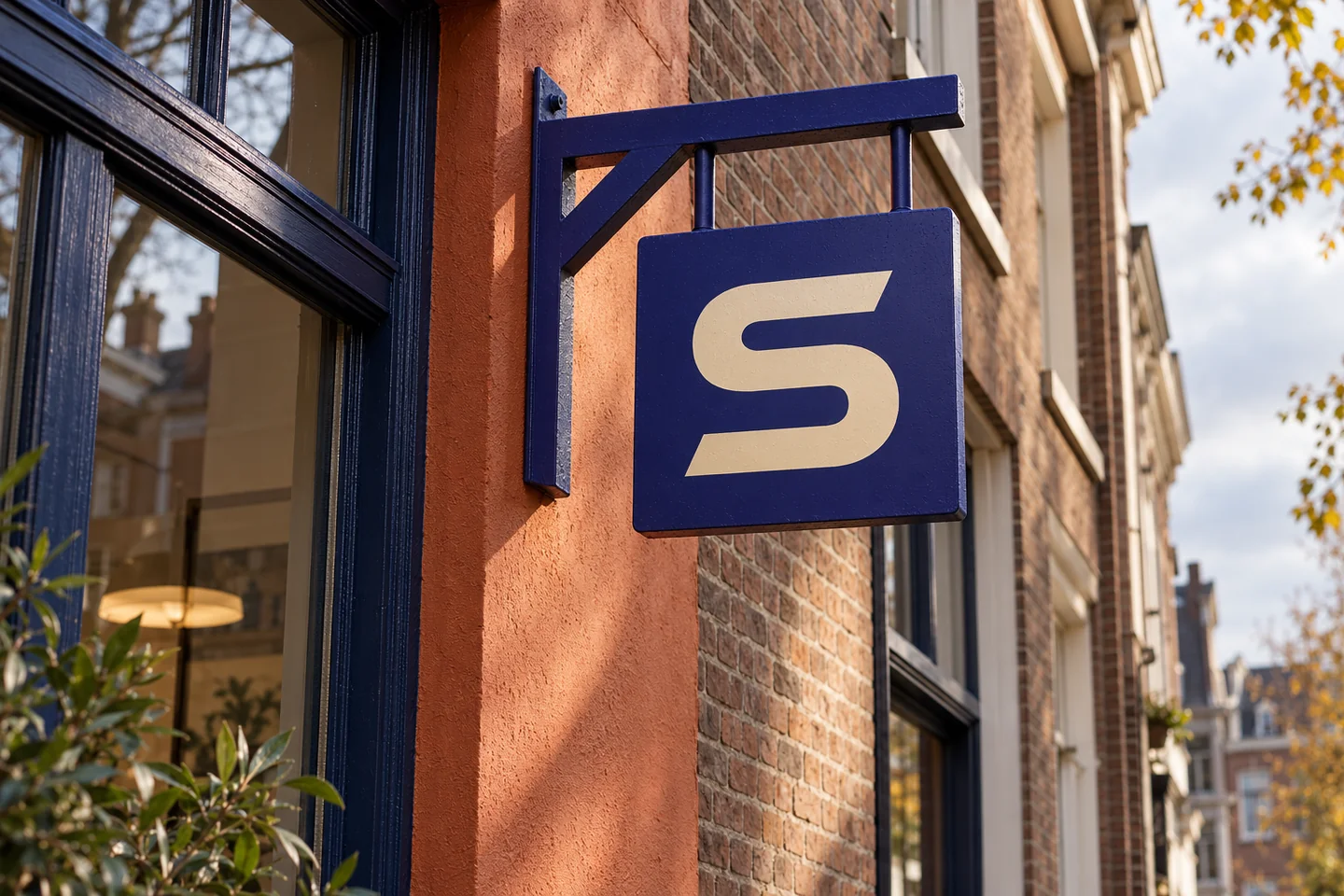 Ultramarijn uithangbord met het S-teken aan een terracotta winkelgevel